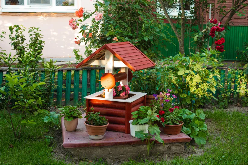 stock-photo-small-garden-backyard-fake-well-with-potted-flowers