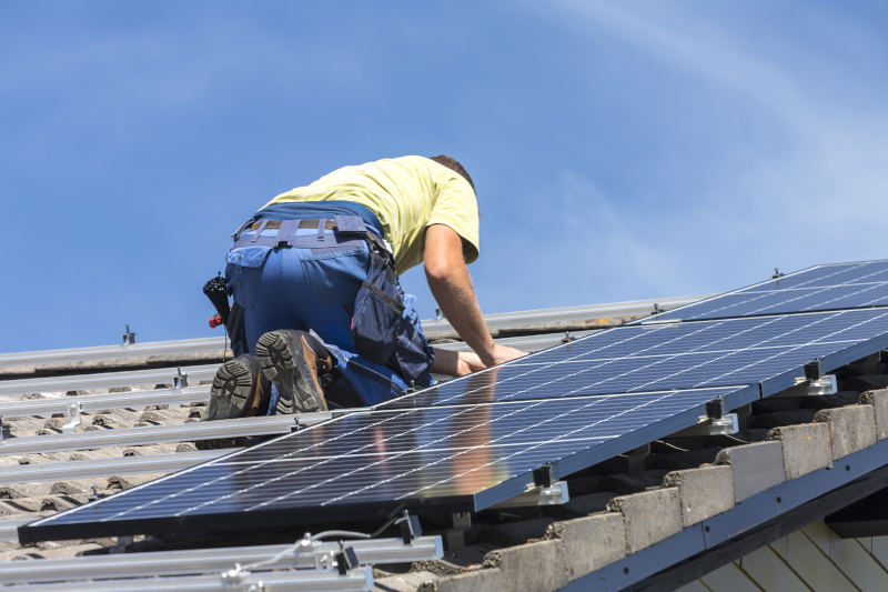 low-angle-view-people-working-roof-against-sky