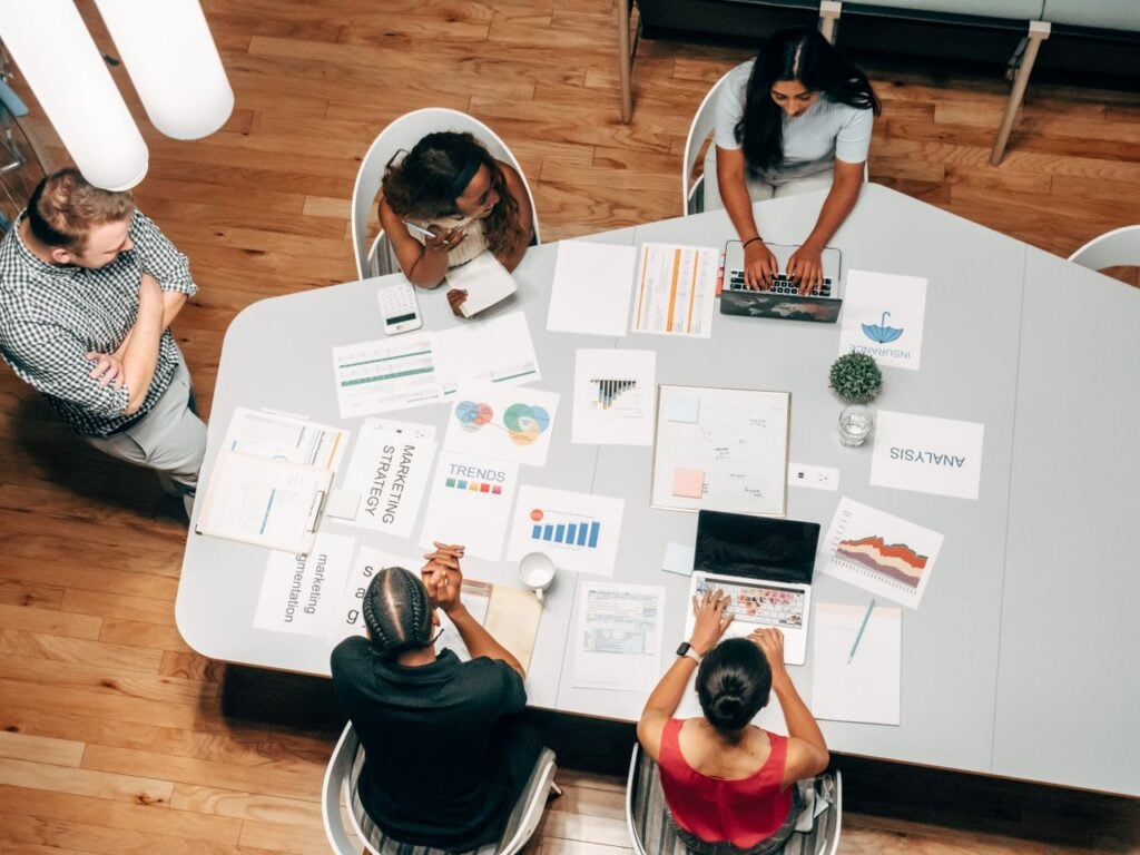 How Successful Entrepreneurs Maximize Productivity A diverse group working on marketing strategies with charts and laptops in an office setting.