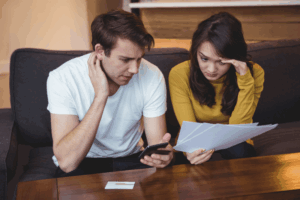 Fixed vs. Variable Annuities: What’s the Difference? 6 couple sitting sofa discussing with financial documents living room