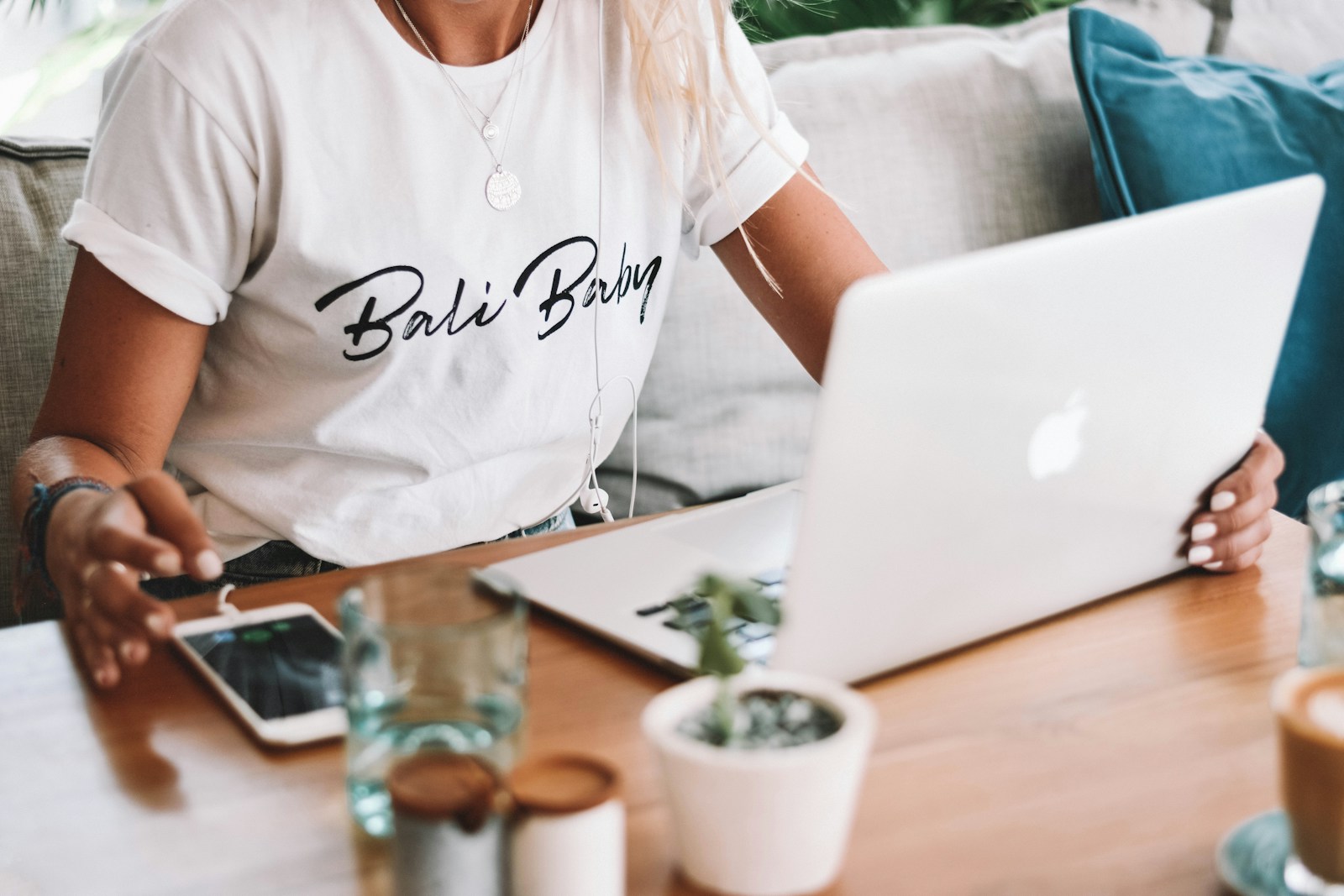 Photo by Content Pixie woman in white crew neck t-shirt sitting by the table with macbook