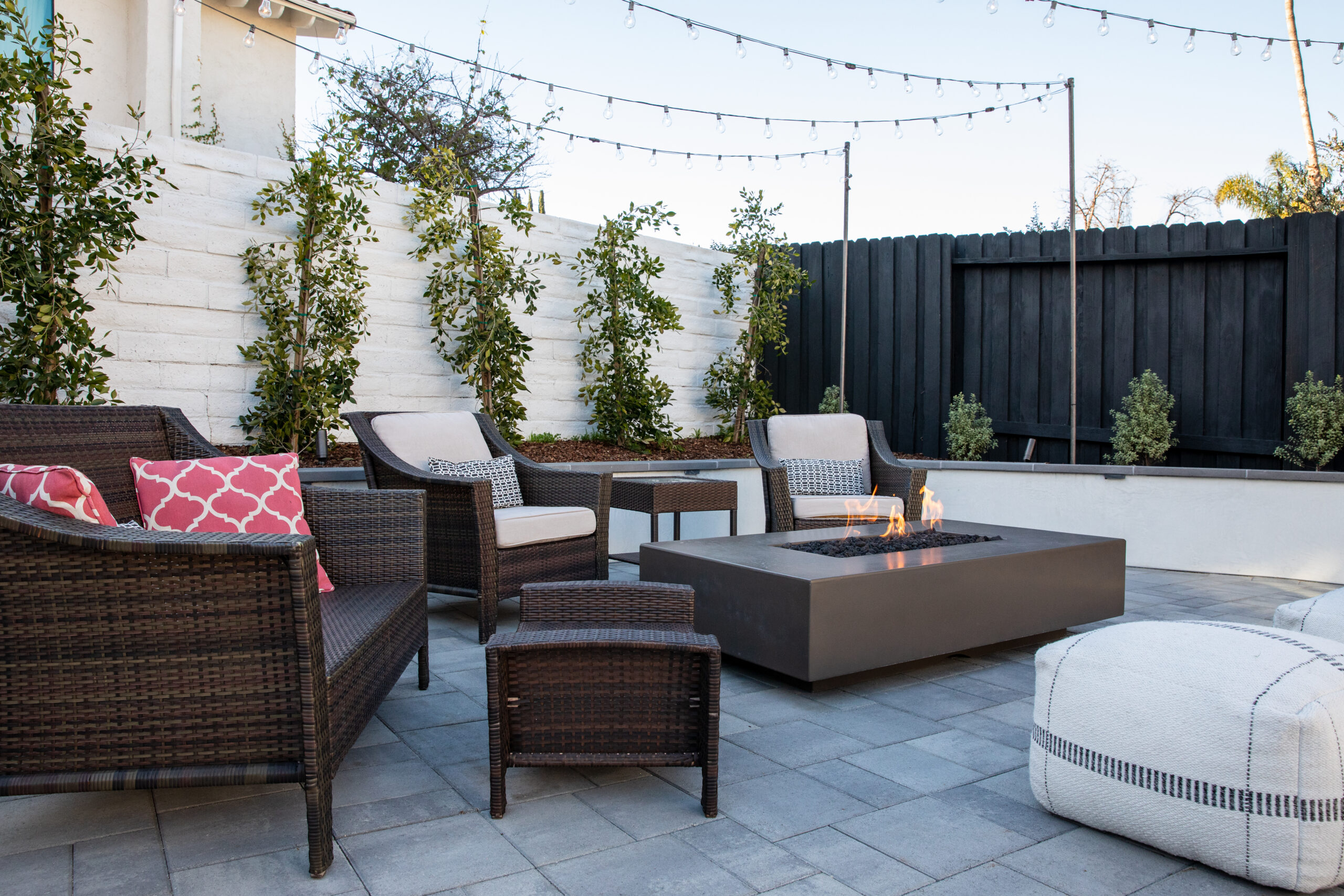 Custom Gas Fire Pit Patio in Ventura County Modern outdoor fire pit patio with lounge seating, string lights, and concrete pavers designed for outdoor entertaining.