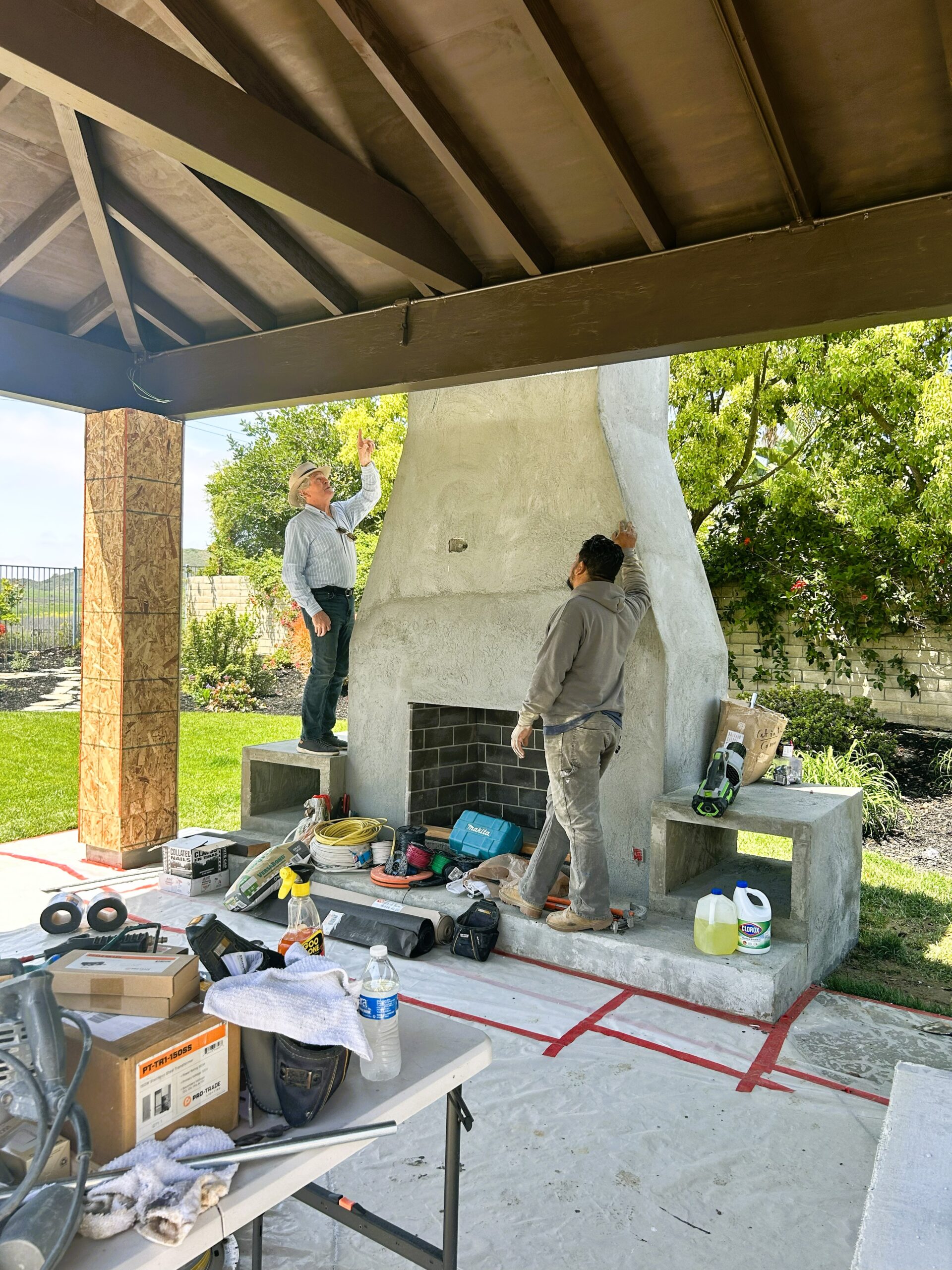 Allen and Jorge Working Two men reviewing the construction of a large masonry fireplace