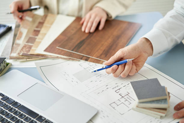 Architect designing a house Landscape architect designing a space with plans and colored samples.