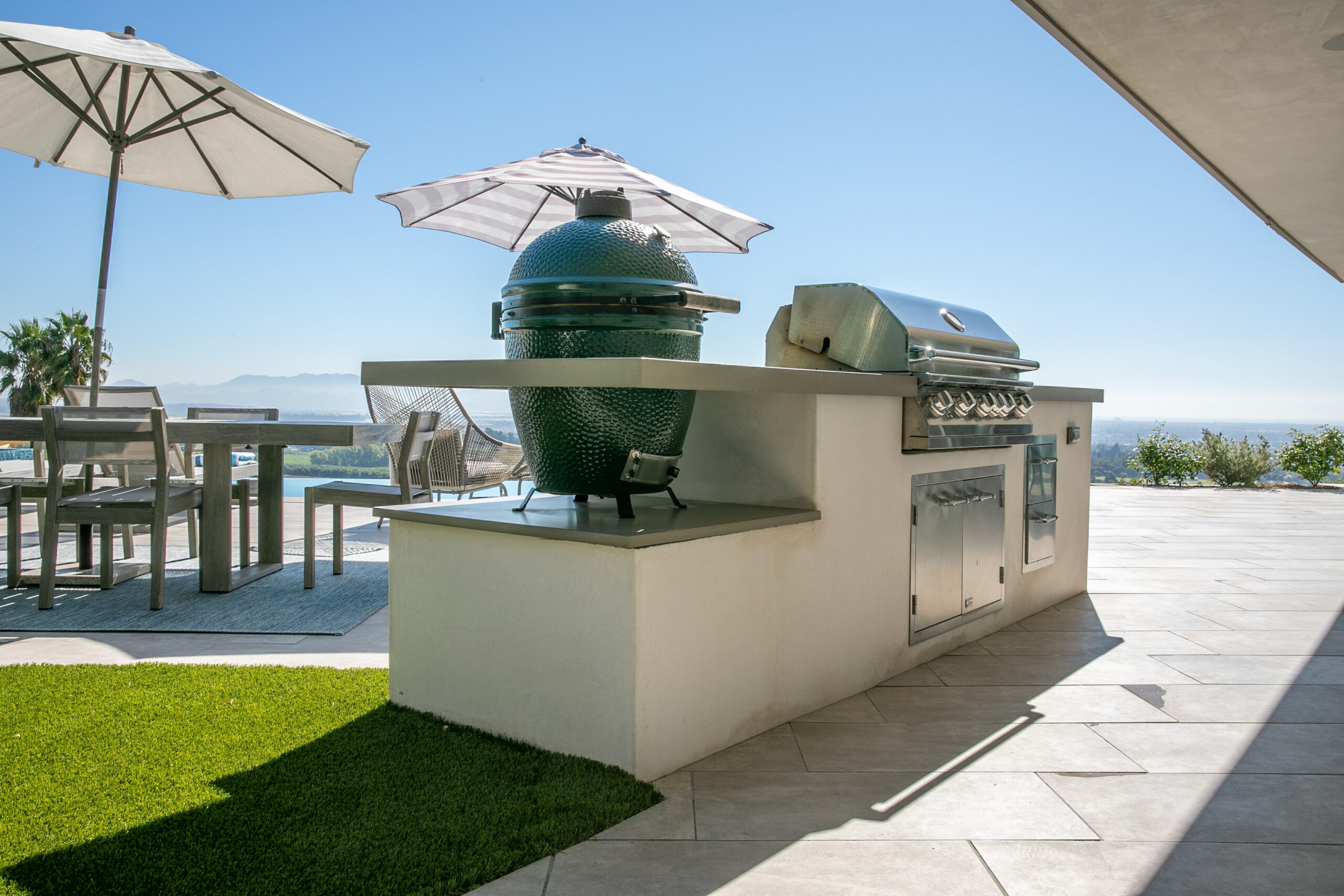 Custom Outdoor Kitchen & Dining Area in Ventura, California Luxury outdoor kitchen with built-in grill, Big Green Egg smoker, dining space, and panoramic views in Ventura, California.