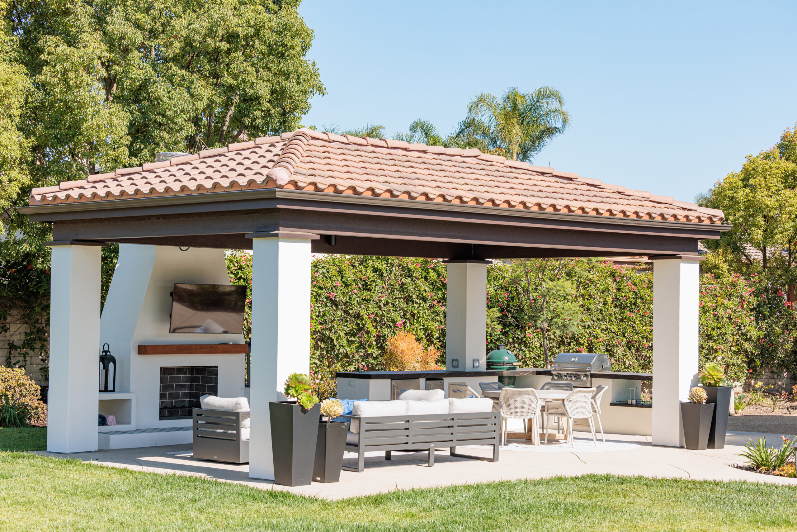 Custom Cabana with Outdoor Kitchen & Fireplace | Newbury Park, CA Custom outdoor cabana in Newbury Park featuring an outdoor kitchen, fireplace, TV, bar seating, lounge area, and tile roof for year-round outdoor living.