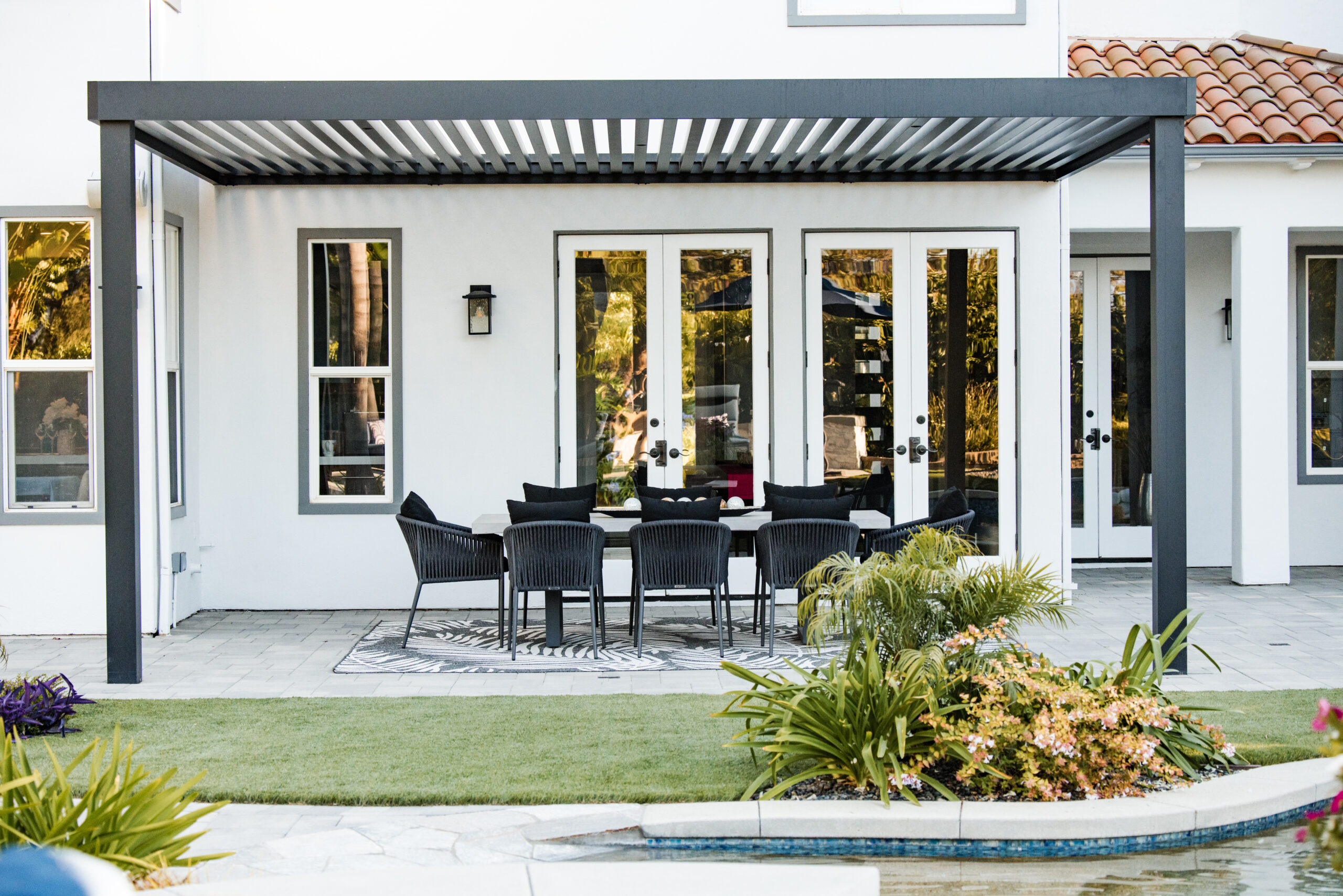 Modern Aluminum Pergola & Outdoor Dining Space | Camarillo, CA Modern aluminum pergola with lattice roof covering an outdoor dining area overlooking a custom swimming pool in Camarillo, California