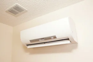 Ductless AC 2 White ductless mini-split AC unit, open flap, and square ceiling vent.