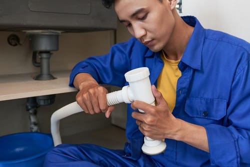What Is an Air Gap in Plumbing? Understanding Its Importance for Backflow Prevention 2 Plumber assembling pipe