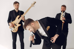 client-satisfaction-img Energetic music band with singer, guitarist and saxophonist performing indoors.