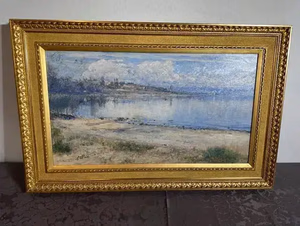 Un paysage encadré représentant un rivage serein aux eaux calmes et une vue lointaine sur la terre et les nuages est précisément « Ce que j'achète ». Le cadre doré et orné rehausse les détails et l'élégance de l'œuvre.