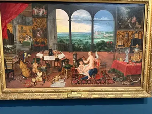 Un tableau détaillé représentant une pièce somptueuse avec des instruments de musique, des livres et des meubles ornés. « Ce que j'achète » représente un homme et un enfant assis avec un chien à leurs pieds. En arrière-plan, une arche ouverte révèle un paysage pittoresque avec un château au loin.