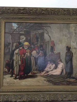 Un tableau représentant une scène historique d'un marché en plein air montre plusieurs personnes en tenue moyen-orientale en train de discuter, tandis que d'autres, dont des nus assis, observent. À l'arrière-plan, peuplé de textiles et d'éléments architecturaux, des murmures de « ce que j'achète » résonnent.