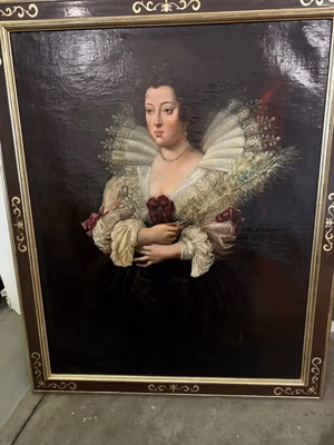 Tableau encadré représentant une femme vêtue d'une robe élaborée avec un large col à volants et des manches bouffantes, tenant un bouquet de fleurs et de verdure, sur un fond sombre. Le cadre est orné de détails dorés.