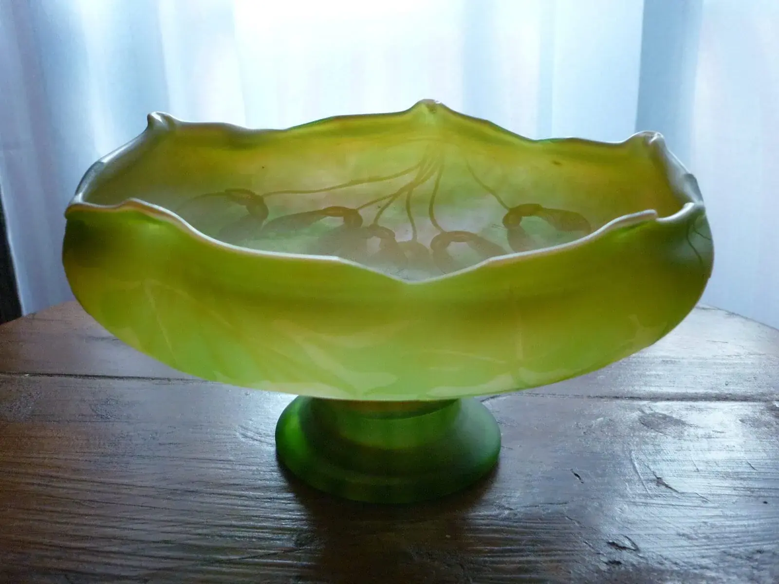Vase en verre vert sur une table en bois.