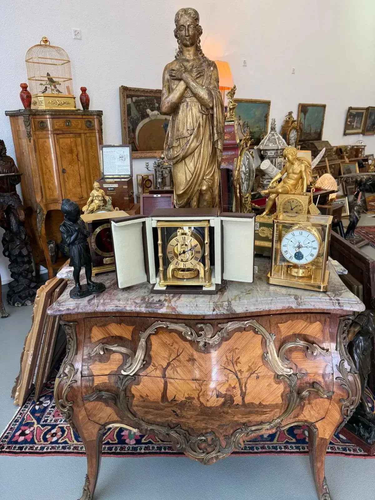 Antiquités variées sur un meuble en bois sculpté.
