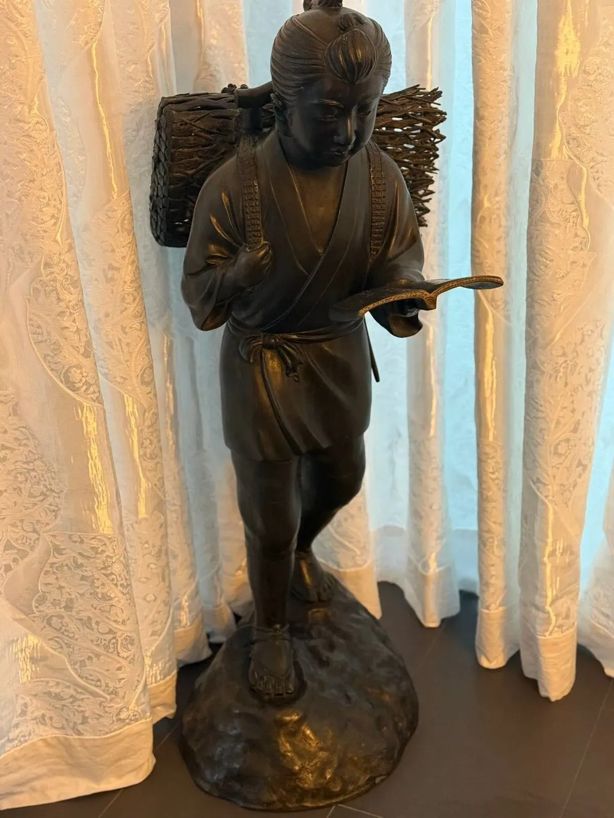 Statue en bronze d'un homme lisant.
