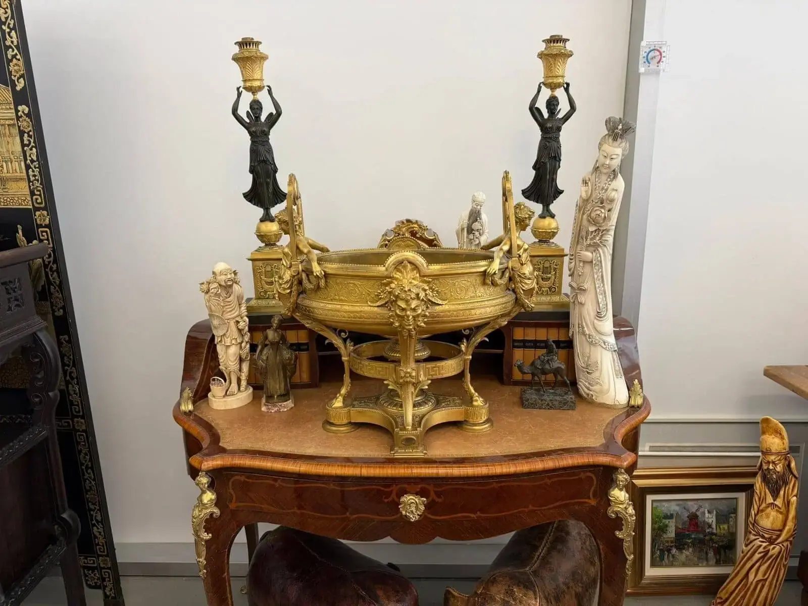Table avec sculptures et objets anciens décoratifs.