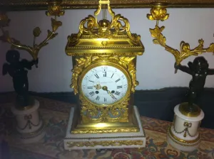 Vergoldete Uhr mit zwei geflügelten Statuetten.