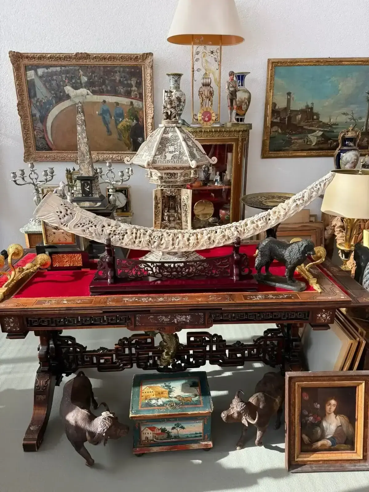 Collection d’objets et peintures anciennes sur une table.