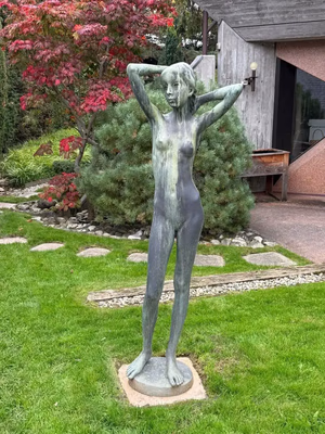 Statue en bronze d'une femme dans un jardin