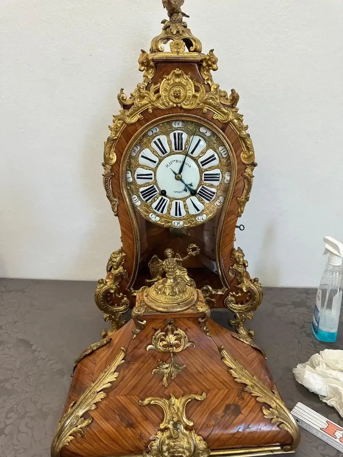 Horloge ancienne en bois et ornements dorés.