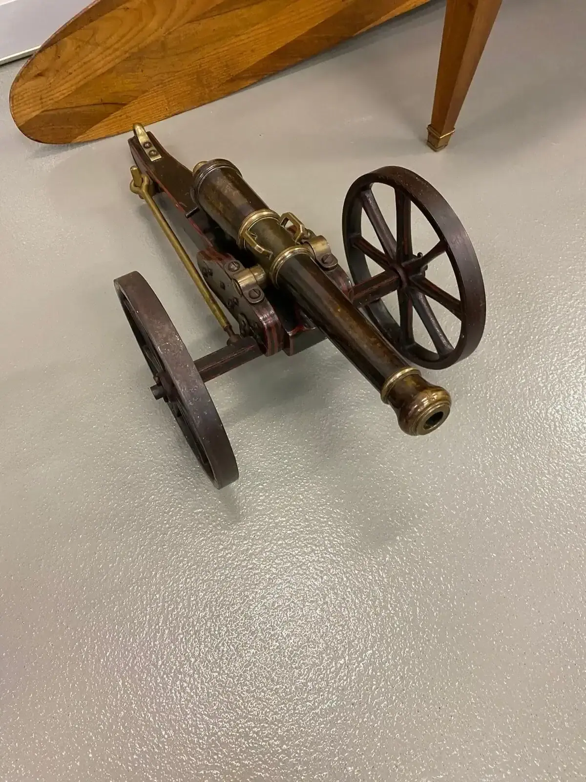 Petit canon ancien en bronze sur roues en bois