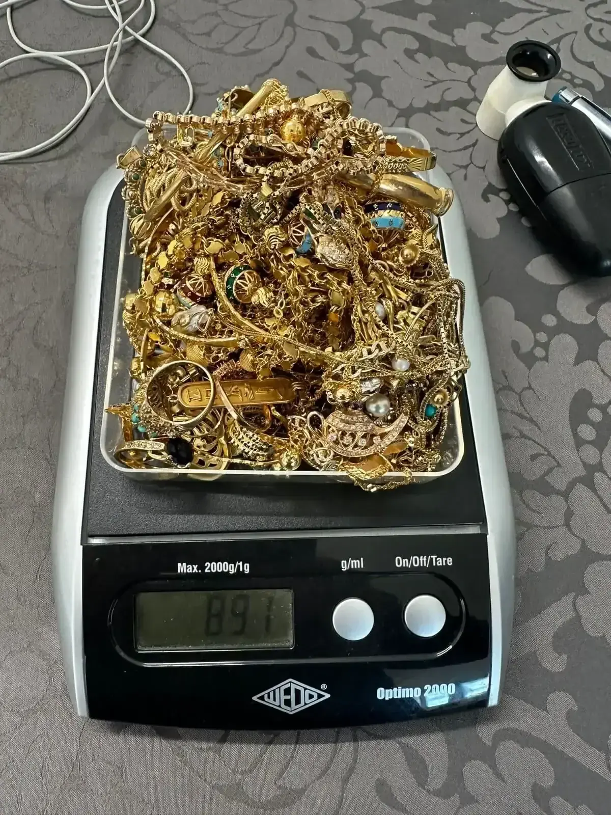 Bijoux en or pesés sur une balance électronique.