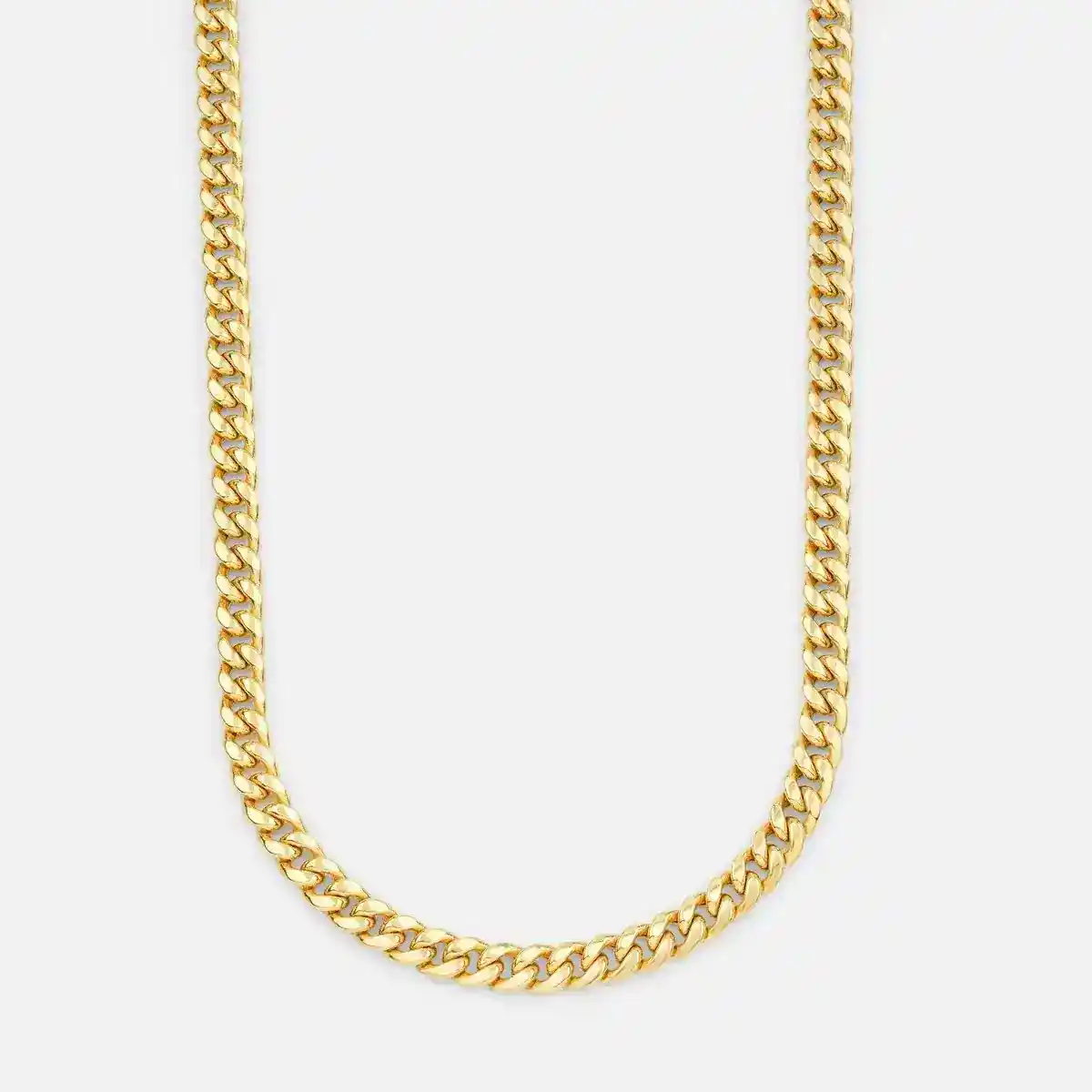 Close-up of a stylish gold chain necklace on a white surface, highlighting its elegance.