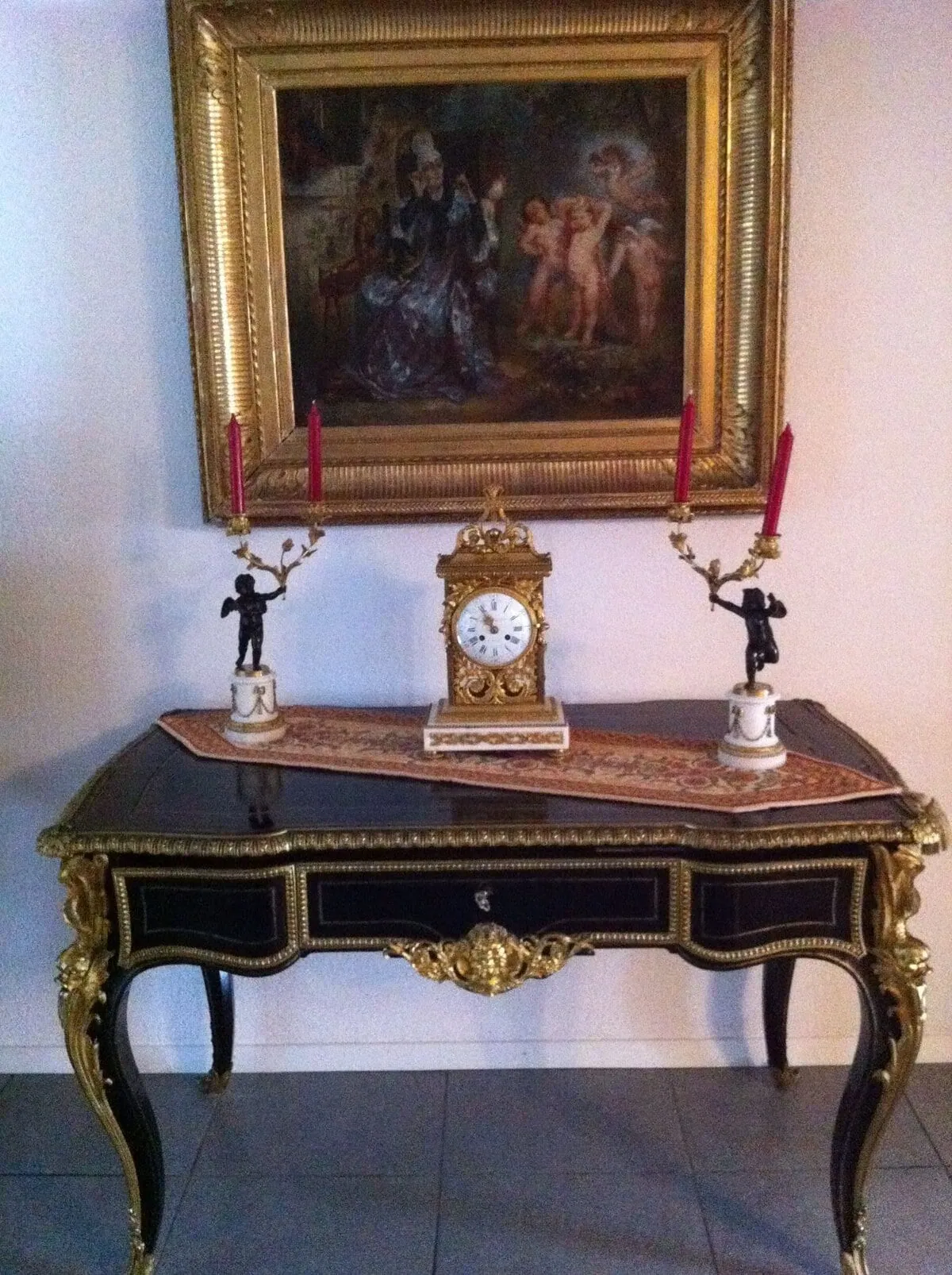 Console ancienne avec horloge dorée et chandeliers