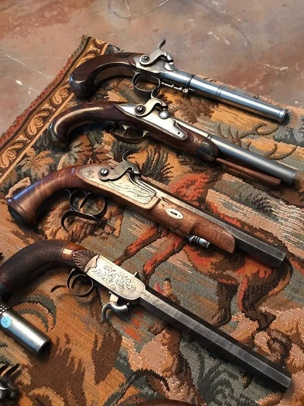 Pistolets anciens exposés sur un tissu décoratif