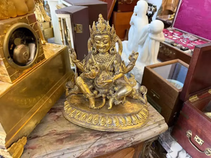 Statue dorée bouddhiste en exposition dans une vitrine.