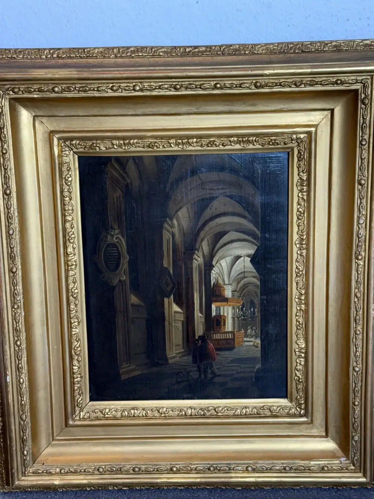 Peinture d’une église ancienne encadrée dorée.