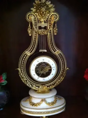 Horloge dorée ancienne en forme de lyre.