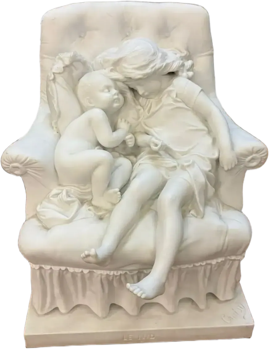 Une sculpture en marbre blanc d'Auvernier représente une jeune fille et un bébé assis sur une chaise rembourrée. La jeune fille se penche vers le bébé, qui la regarde - tous deux pieds nus, avec des détails délicats dans leurs vêtements et les expressions de leur visage.