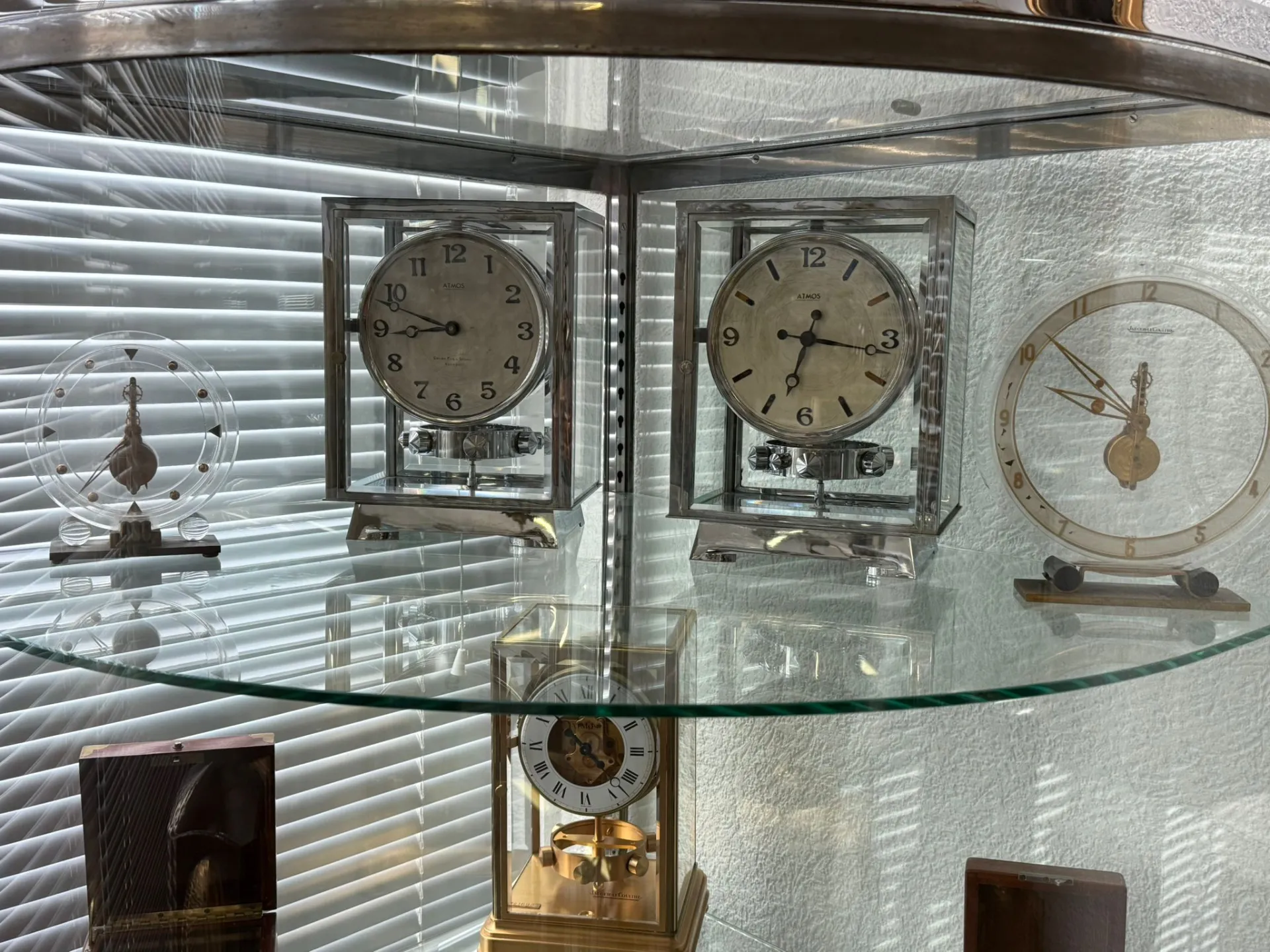 Collection d’horloges anciennes sous vitrine en verre