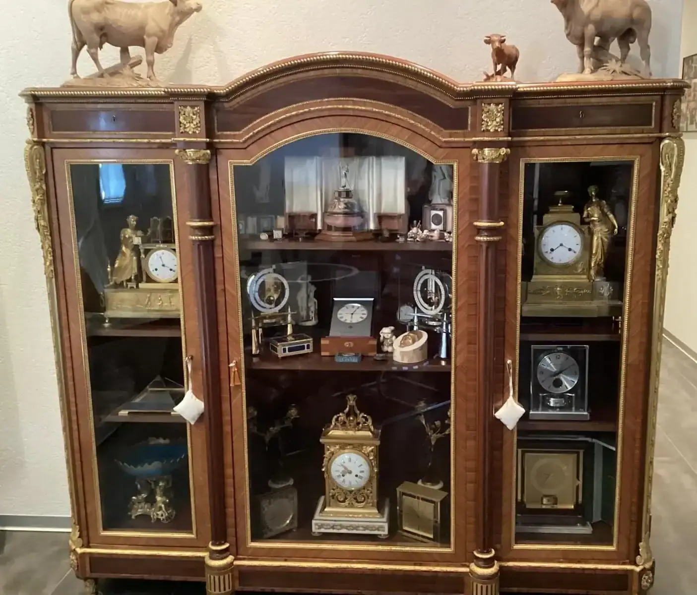 Vitrine en bois avec montres et horloges anciennes