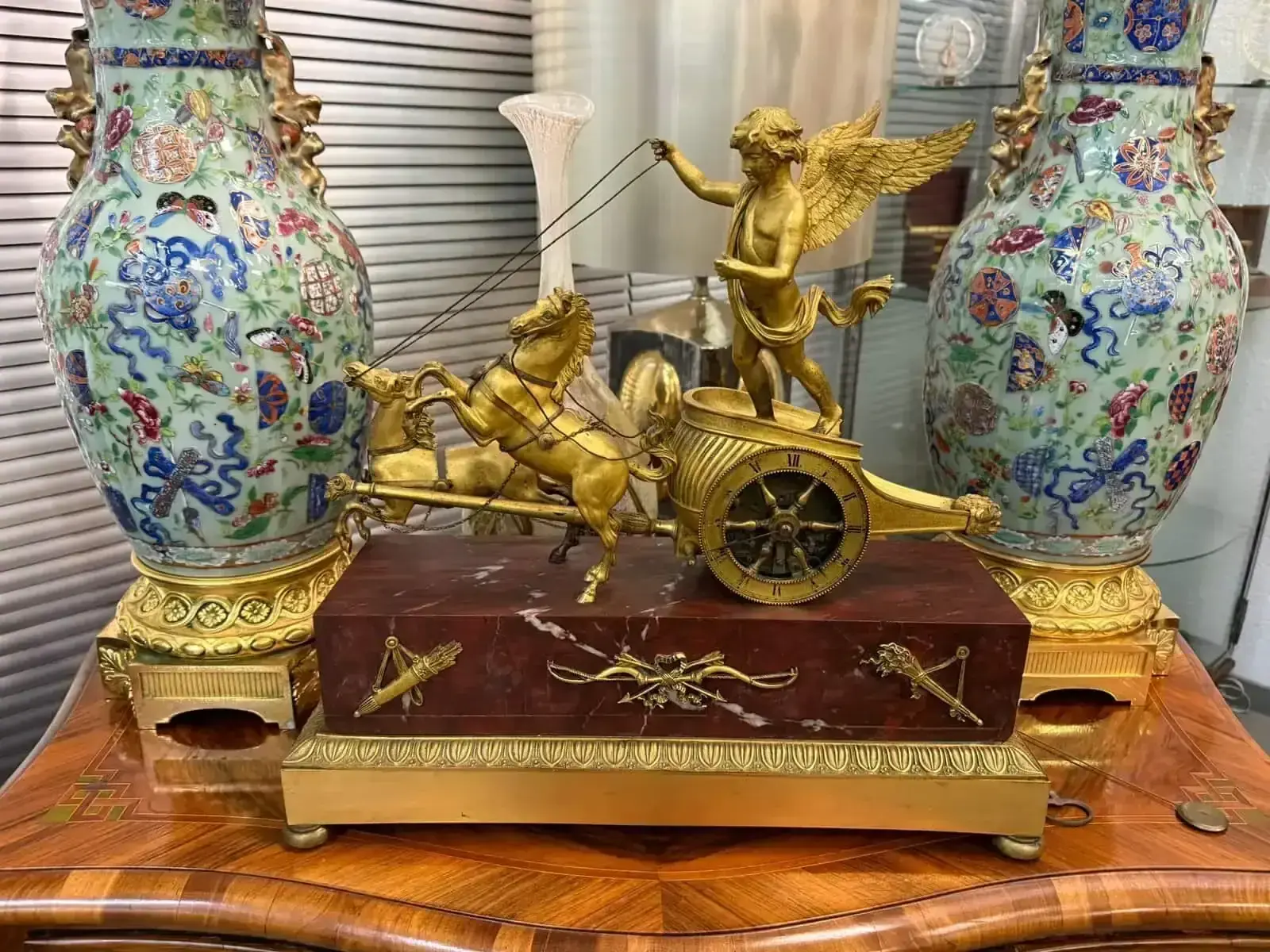 Horloge antique dorée avec ange et chevaux.