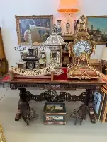 Table avec horloges anciennes et objets décoratifs.