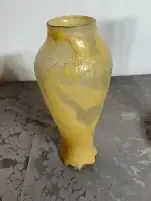 Vase en verre jaune décoratif sur une table grise