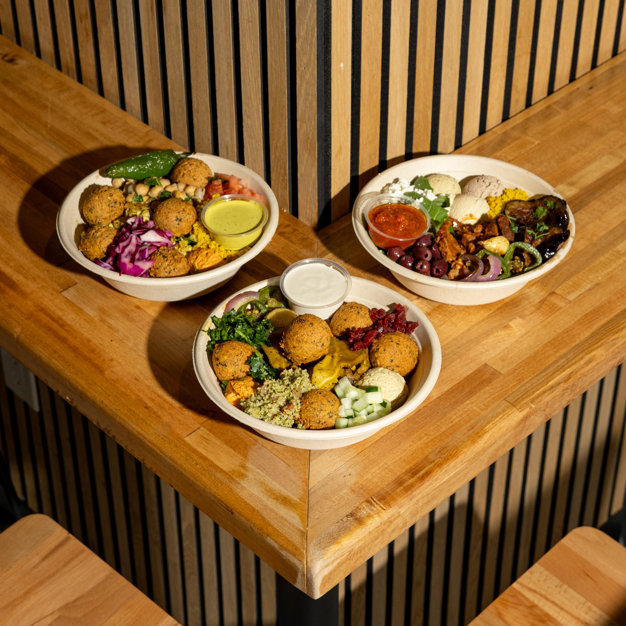 How to Calculate ROI on a Food Franchise Before You Sign Anything Fresh hummus bowls and Mediterranean wraps displayed on a fast-casual restaurant counter — a strong example of how to calculate roi on a food franchise by starting with a high-margin menu concept.