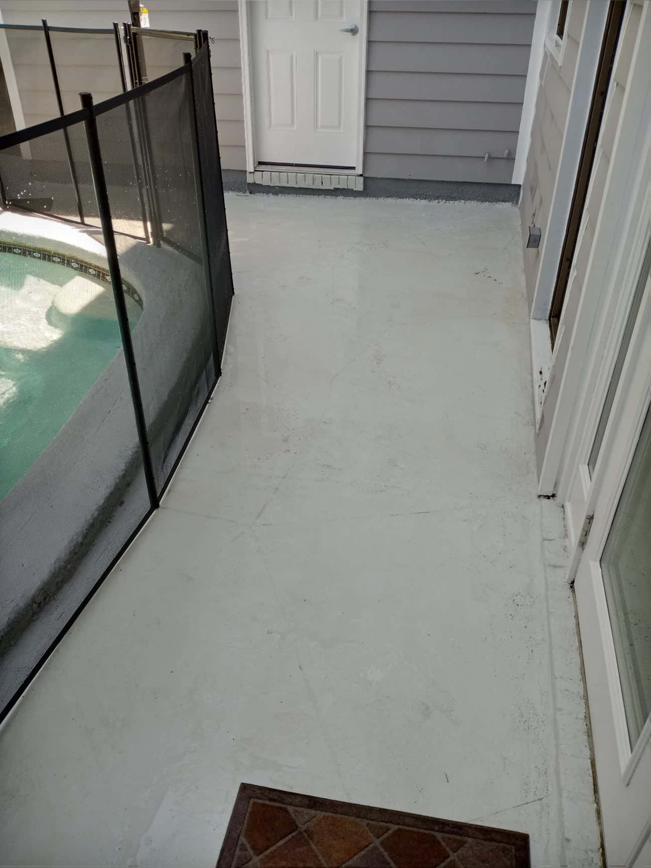Worker using hot water pressure washing on a concrete driveway, illustrating hot water pressure washing benefits.