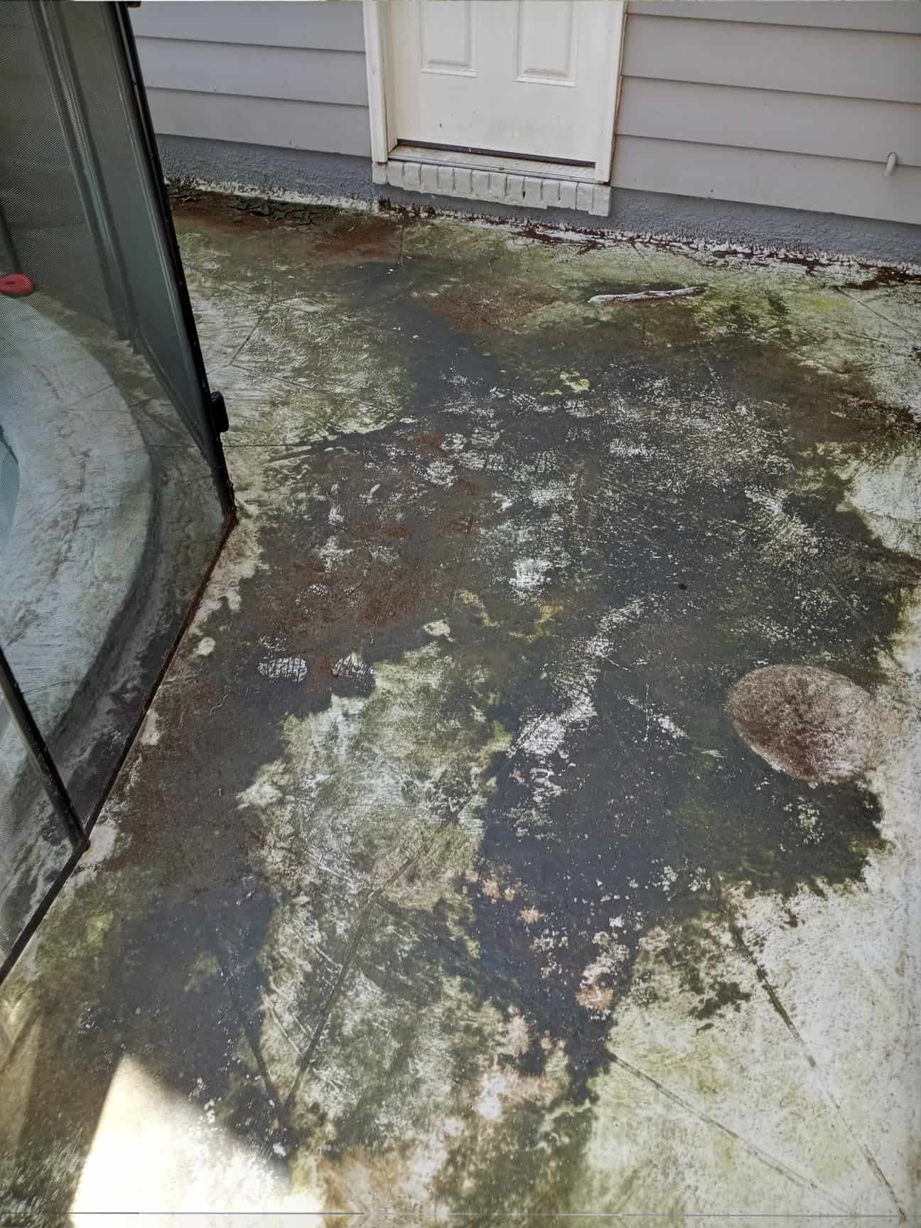 hot water pressure washing benefits - A technician uses hot water pressure washing on a concrete driveway, demonstrating bene
