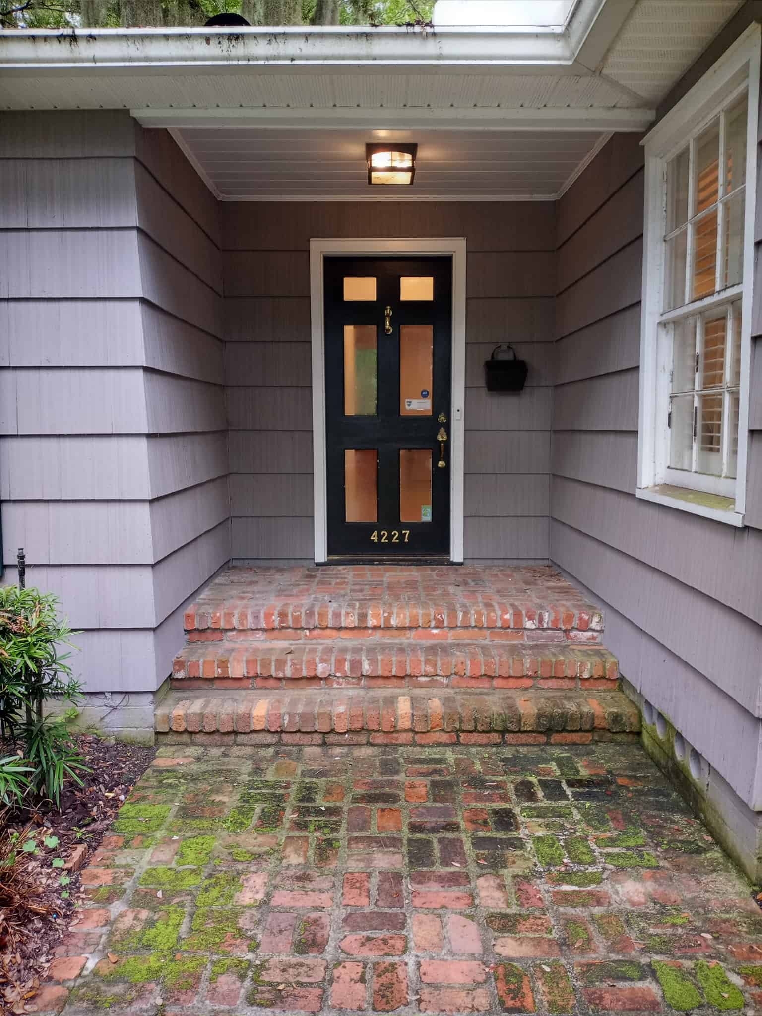 A professional pressure washer cleans a concrete driveway, showcasing hot water pressure washing benefits by removing grime e