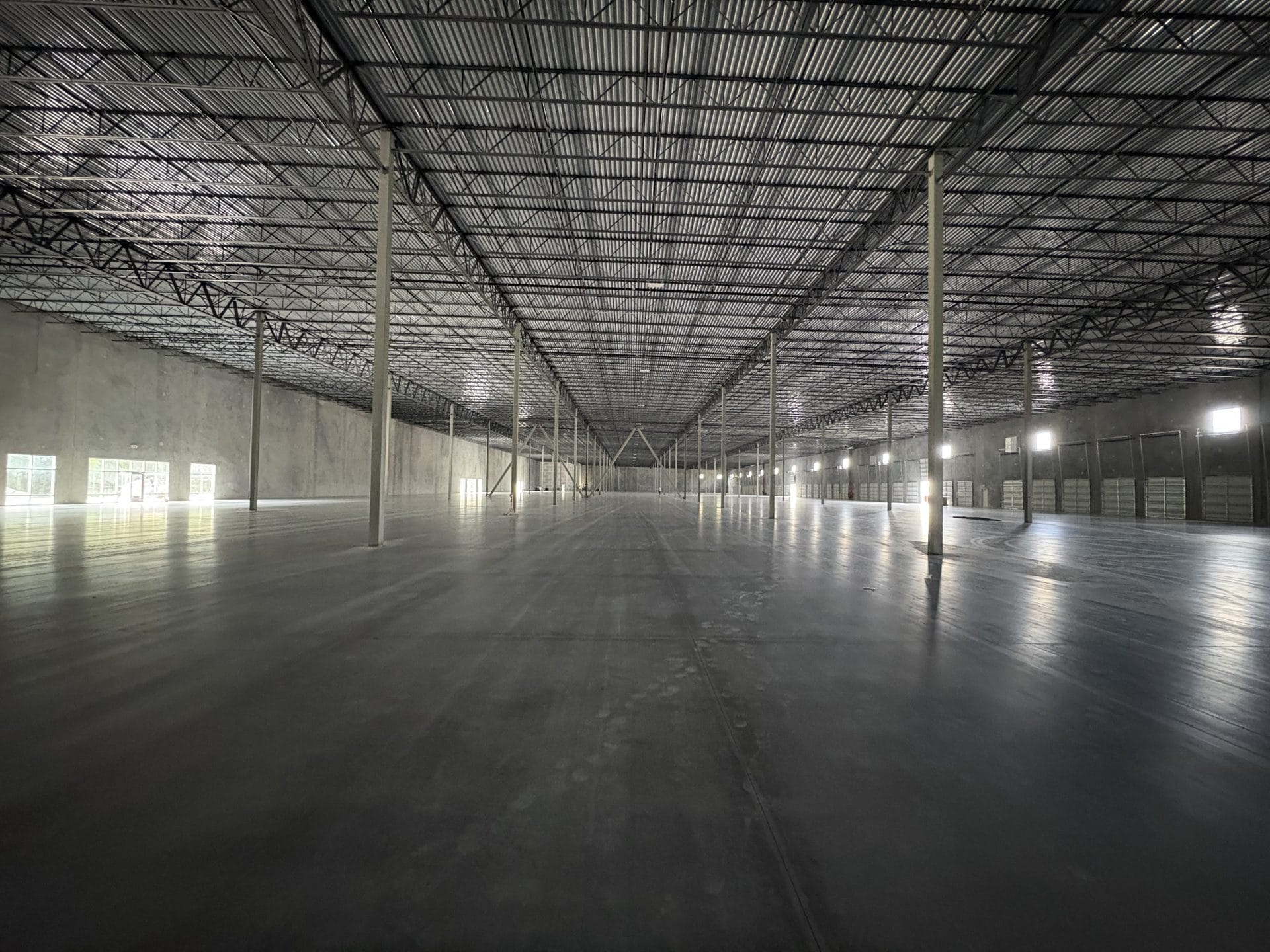 warehouse interior contractor Jacksonville - Spacious warehouse interior with high ceilings and organized shelving, showcasin