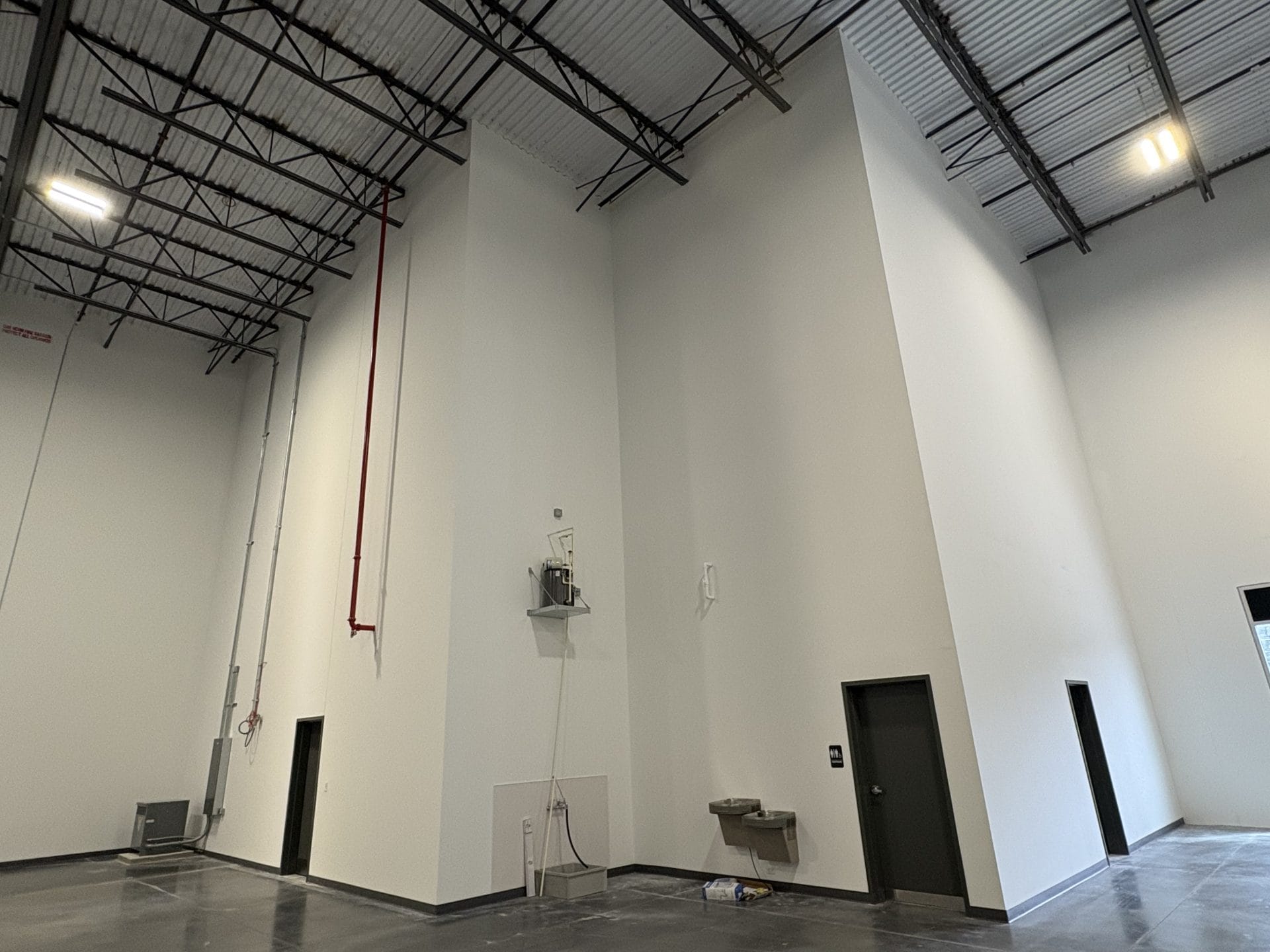 warehouse interior contractor Jacksonville - Spacious warehouse interior under construction with exposed beams and concrete f