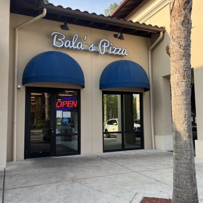 Balas pizza restaurant interior with modern decor, featuring wooden tables, pendant lighting, and a cozy atmosphere.