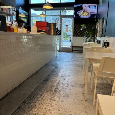 Modern Vietnamese restaurant interior with wooden tables, green plants, and ambient lighting creating a cozy atmosphere.