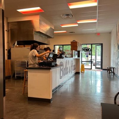Balas Pizza storefront with a modern design, featuring large windows and a welcoming entrance, located in a bustling area.
