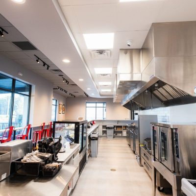 Modern restaurant interior under Jacksonville restaurant construction with exposed beams and unfinished walls.